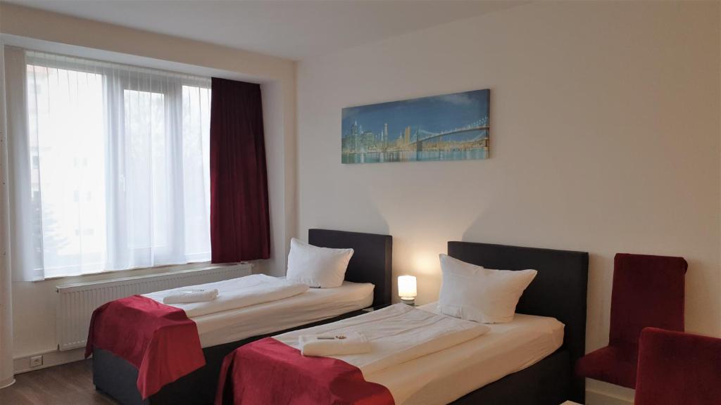 ジンスハイムにあるApart-Hotel-Kickのベッド2台と窓が備わるホテルルームです。