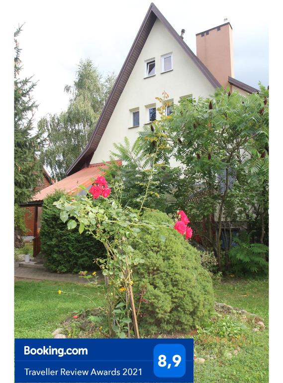 a house with a flowering bush in front of it at Apartament Leśny in Supraśl