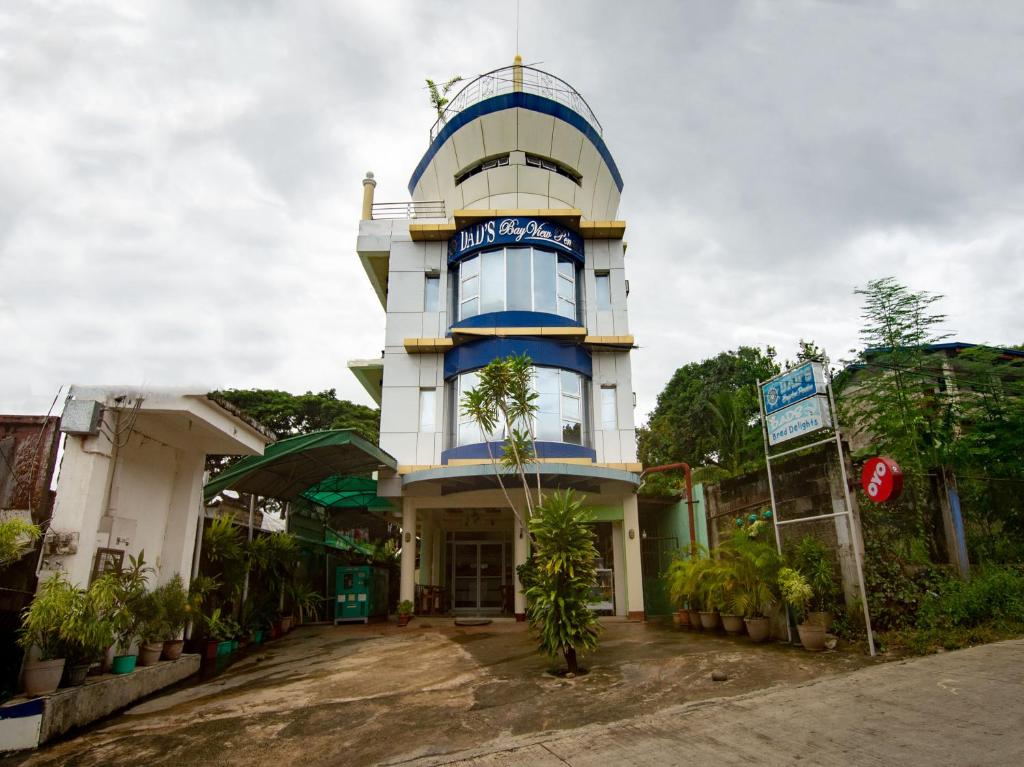 un bâtiment bleu et blanc avec un panneau sur lequel figure un panneau dans l'établissement OYO 554 Dads Bayview Pension, à Puerto Princesa