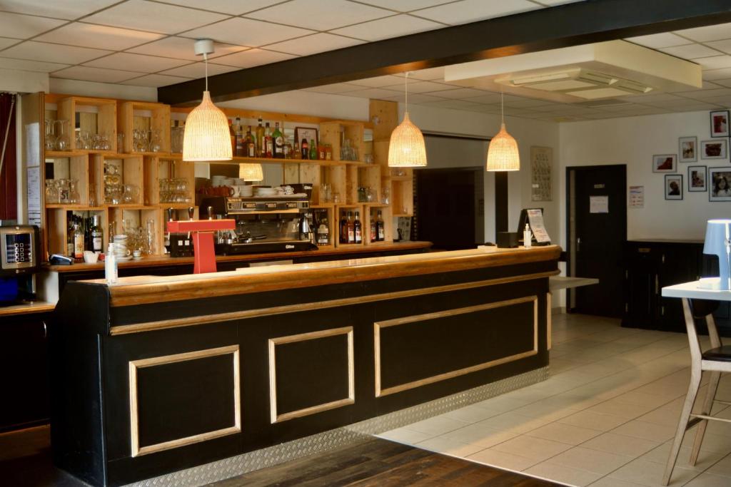 un bar en un restaurante con dos luces colgantes en HOSTEL Les Bois Verts - Les Herbiers en Les Herbiers