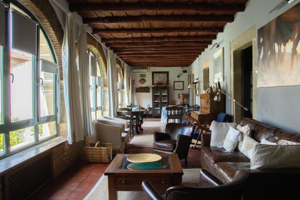 sala de estar con sofá, sillas y ventanas en Casa Rural Antolina, en San Martín de Trevejo