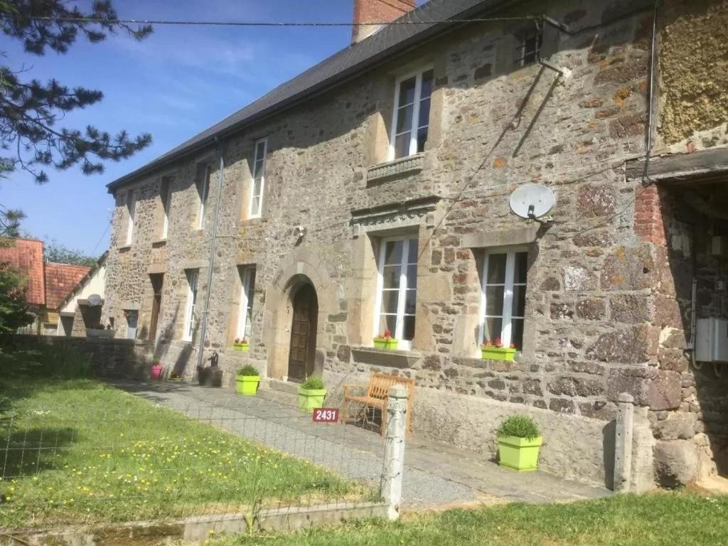 an old stone building with plants in front of it at La Petellerie, maison de campagne avec piscine pour un séjour détente in Moyon