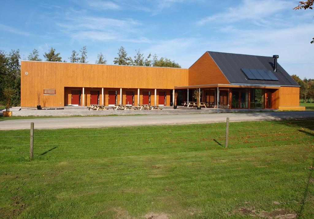 un gran edificio naranja con techo negro en Kyst- og Fjordcentret, en Ørsted