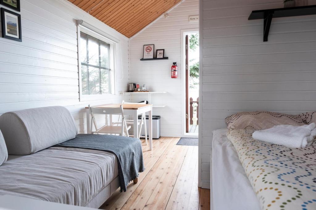 ein Schlafzimmer mit einem Bett und einem Tisch in einem Zimmer in der Unterkunft Smáratún Cottages & Chalets in Hellisholar