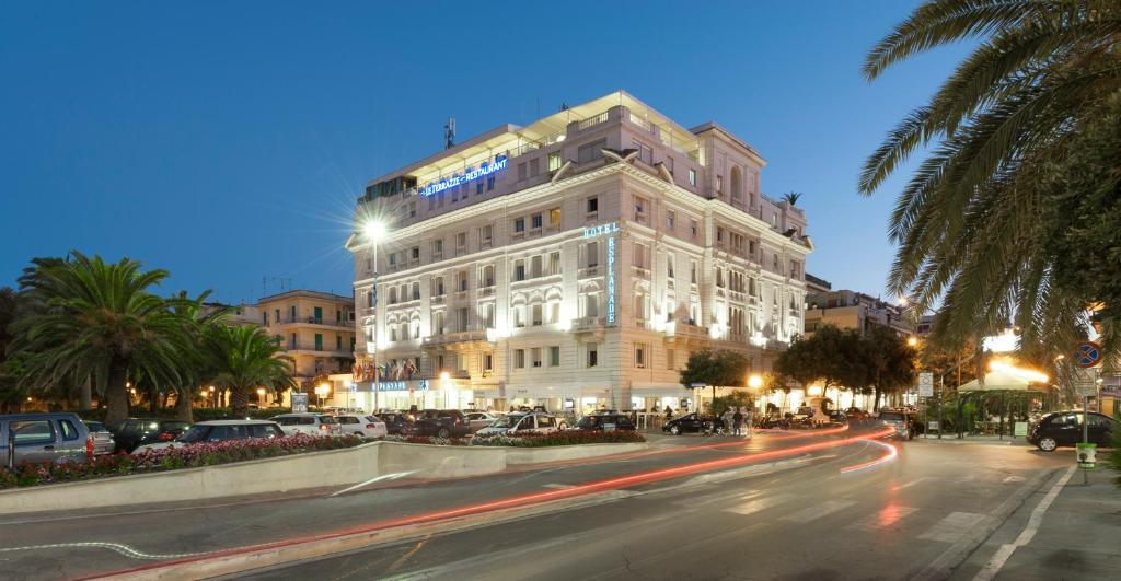 a large white building on a city street at night at Hotel Esplanade in Pescara