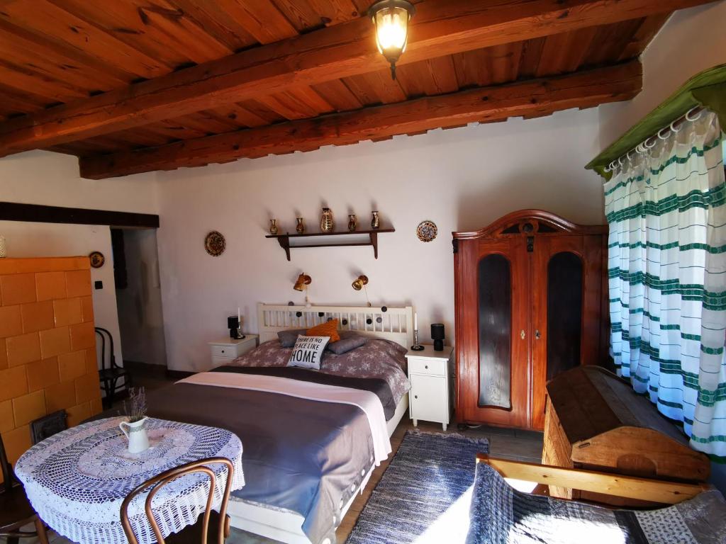 1 dormitorio con 1 cama y 1 mesa en una habitación en Őrség Kincse Kis Apartman - 4 főre, en Hegyhátszentjakab