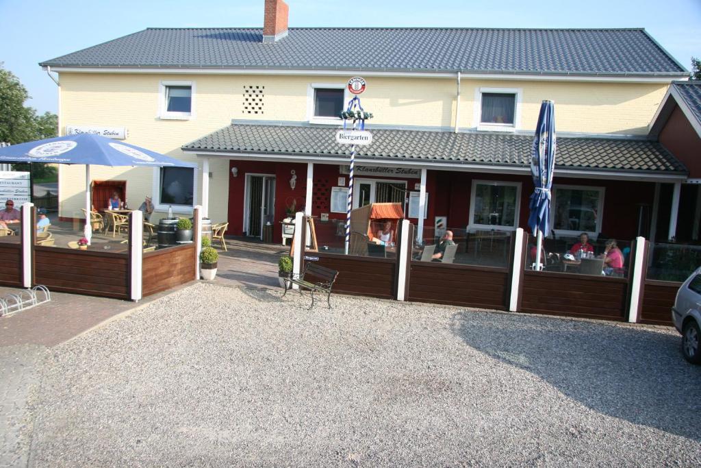 ein Restaurant mit einem Zaun und einer Terrasse im Freien in der Unterkunft Hotel-Klanxbüller-Stuben in Neukirchen