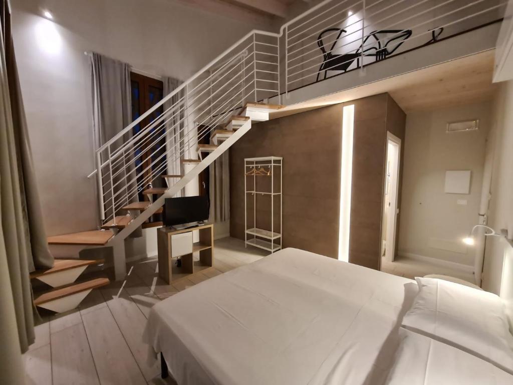 a bedroom with a bed and a spiral staircase at B&B Locanda de' Colli in Signa