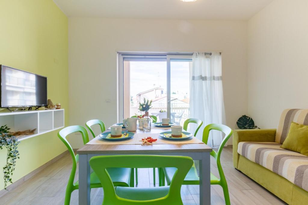 een woonkamer met een tafel en stoelen en een bank bij Giada 2P - Palazzina Laura MyHo Casa in Tortoreto Lido