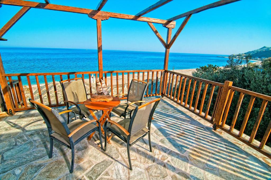 una mesa y sillas en un balcón con vistas al océano en Flamingo Hotel Pelion - Seaside Superior Studios & Suites, en Khorevtón