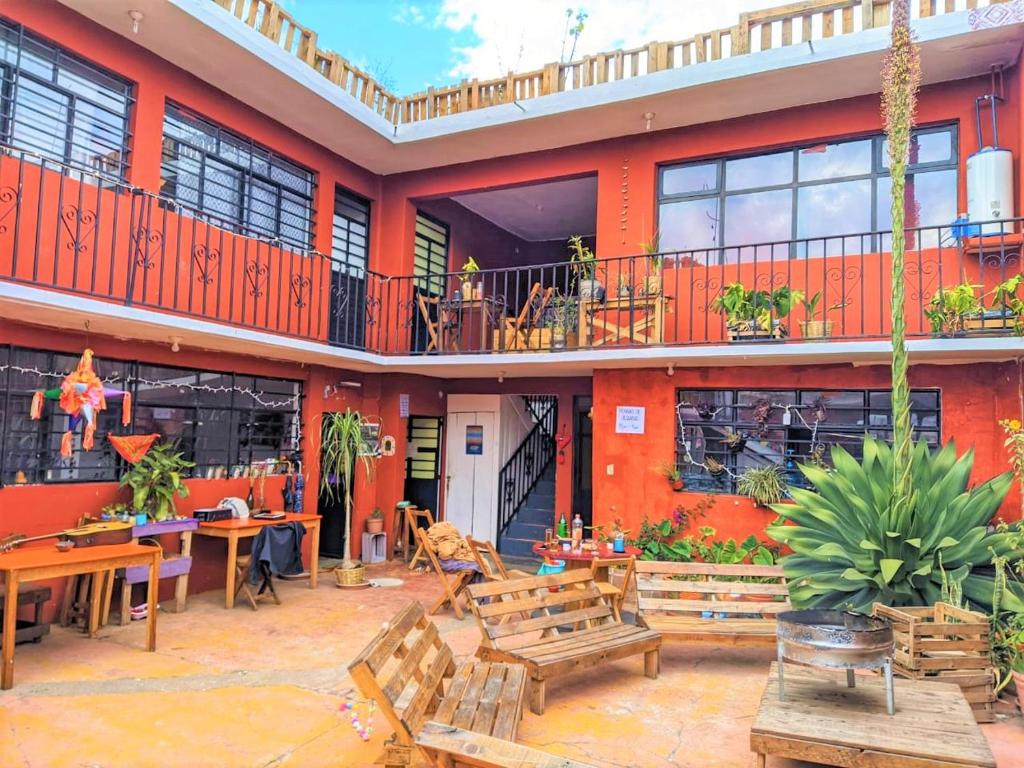 un patio extérieur avec des bancs et des tables ainsi qu'un bâtiment dans l'établissement Casa Huipil, à San Cristóbal de Las Casas