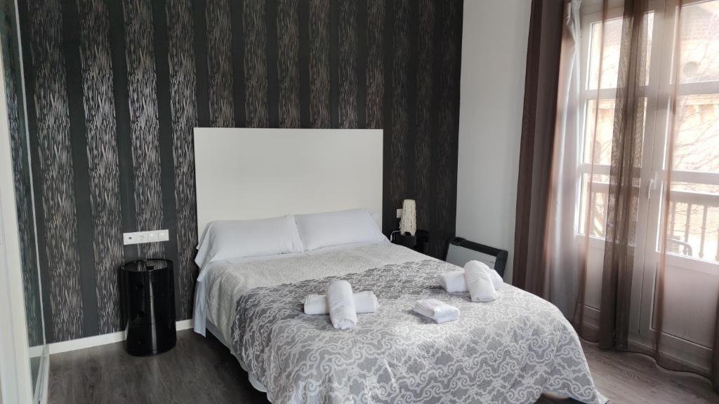 een slaapkamer met een bed met twee handdoeken erop bij Hotel Oleum in Belchite
