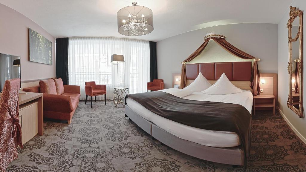 a bedroom with a large bed and a living room at Hotel Sonne in Füssen
