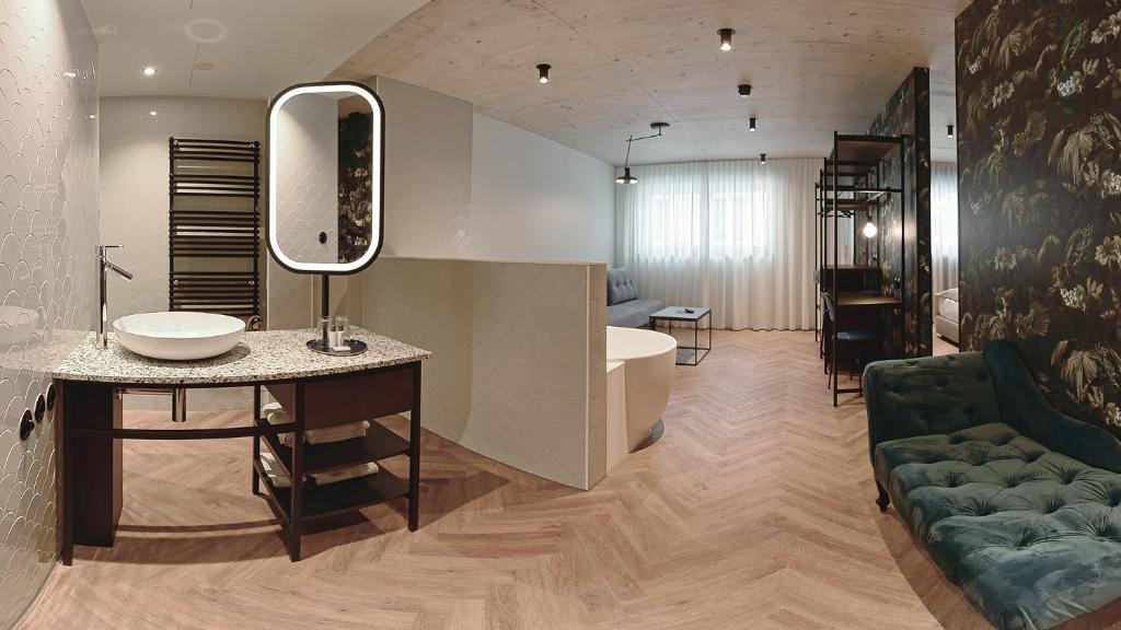 a bathroom with a sink and a bath tub at Hotel Sonne in Füssen