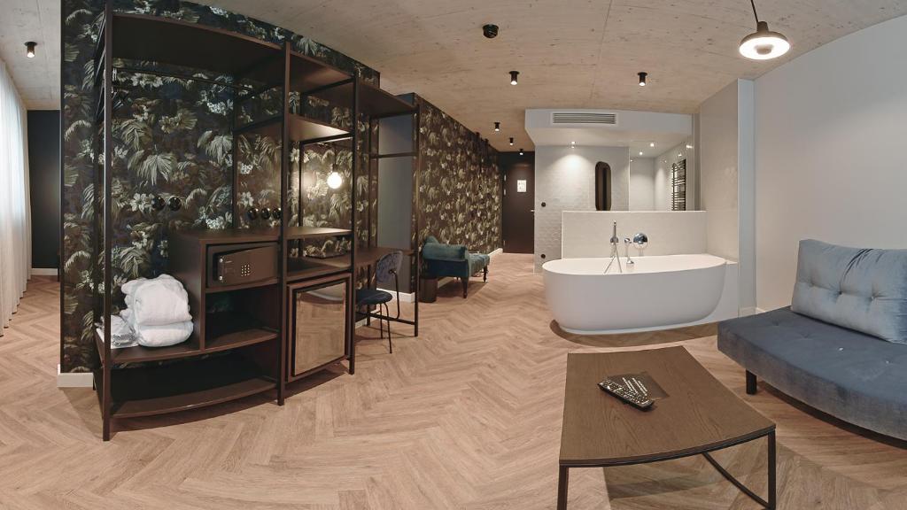 a living room with a bath tub and a couch at Hotel Sonne in Füssen