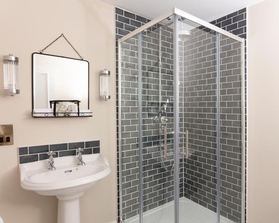 a bathroom with a sink and a glass shower at The Whittling House in Alnmouth