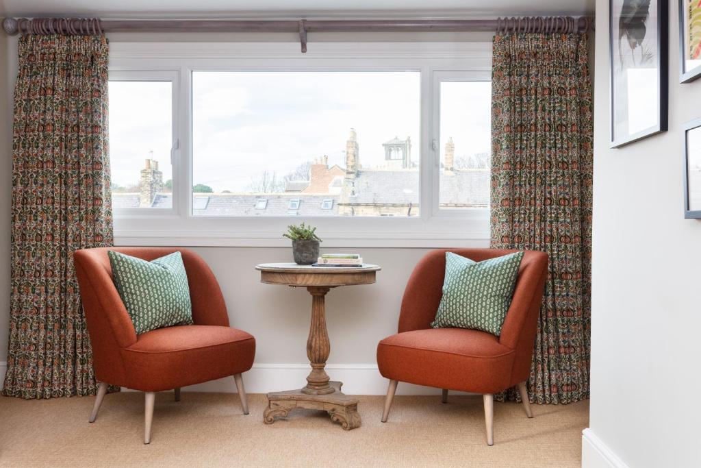 two chairs and a table in front of a window at The Whittling House in Alnmouth