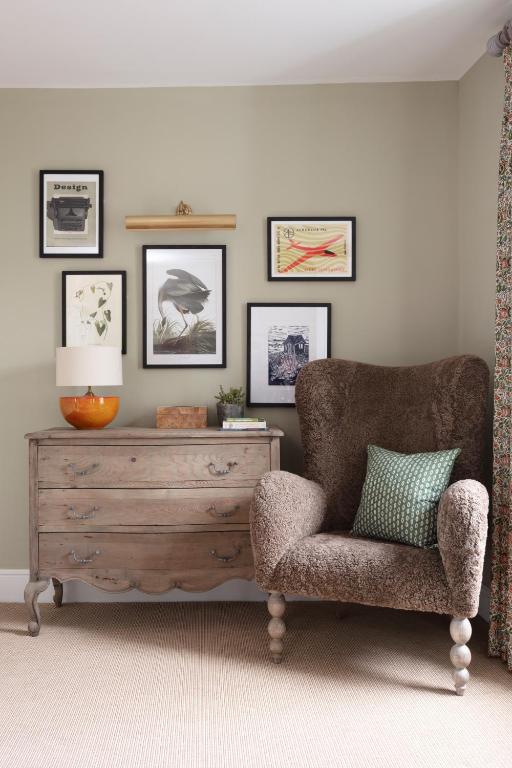 a living room with a chair and a dresser at The Whittling House in Alnmouth