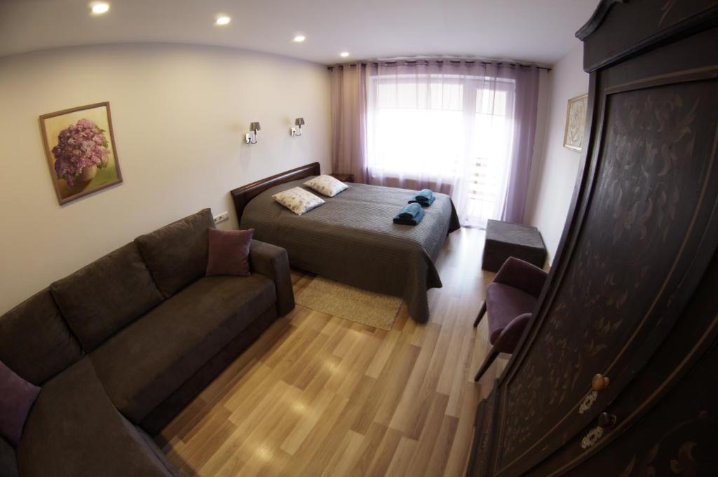 een slaapkamer met een bed en een bank bij Jūrkalnes apartamenti in Jūrkalne