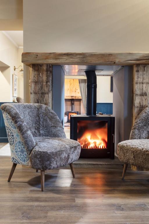 a living room with two chairs and a fireplace at The Whittling House in Alnmouth