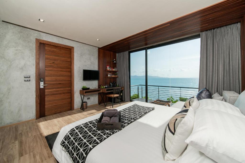 a bedroom with a large white bed and a desk at The Cabin Beach Resort in Haad Rin