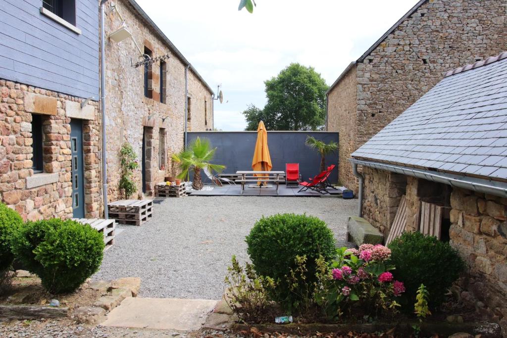 een binnenplaats tussen twee gebouwen met een tafel en een paraplu bij Maison de 3 chambres avec spa jardin clos et wifi a Sains in Sains