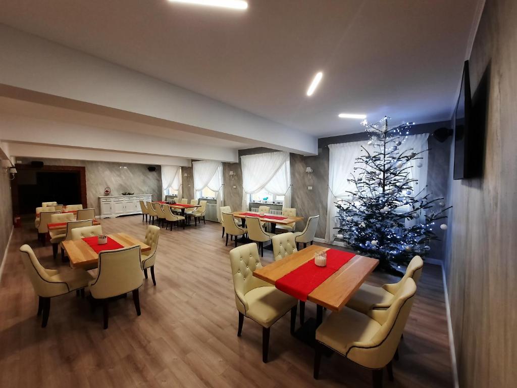 um restaurante com uma árvore de Natal e mesas e cadeiras em Pensiunea Montana Borșa MM em Băile Borşa