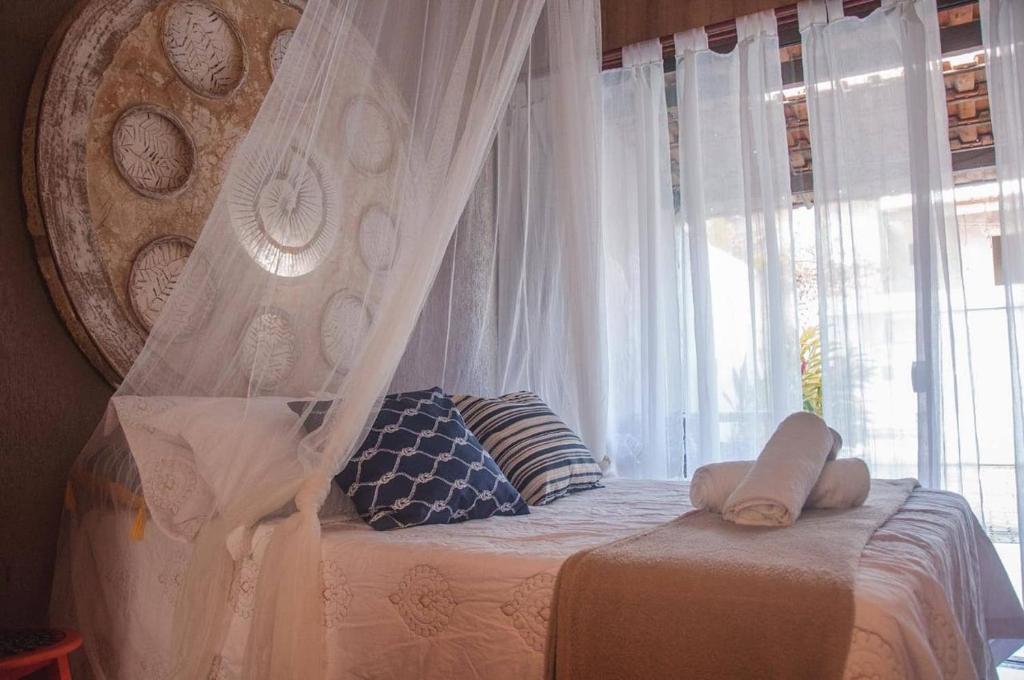 a bedroom with a canopy bed with a window at Loft Caeté in Araruama