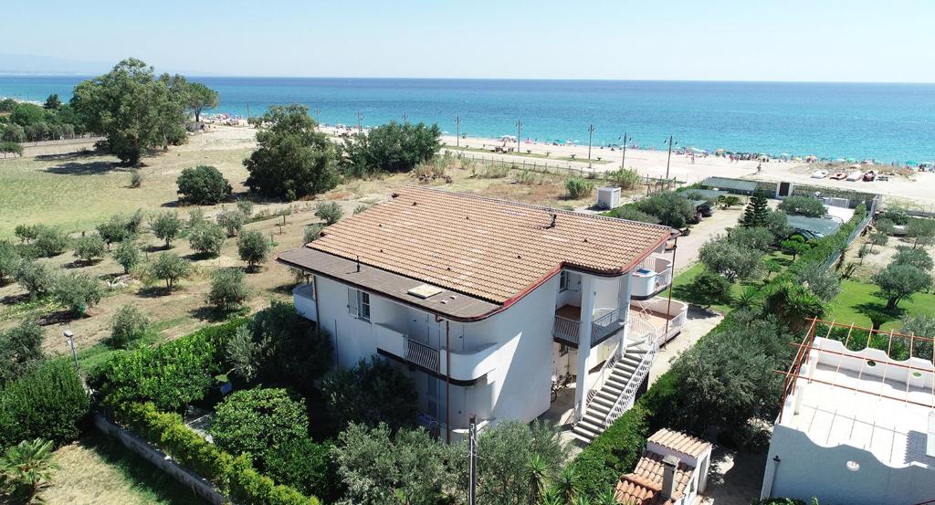 ein Gebäude mit einem Kacheldach neben einem Strand in der Unterkunft Villa Tigani in Soverato Marina