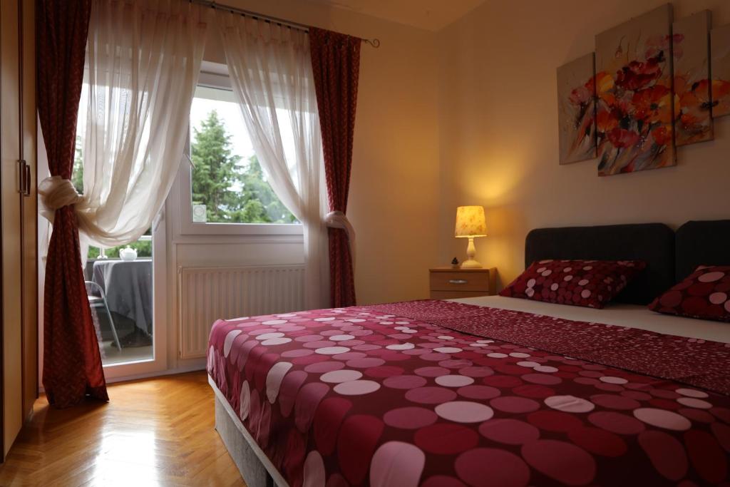 a bedroom with a bed and a large window at Apartment Cvjetna in Rijeka
