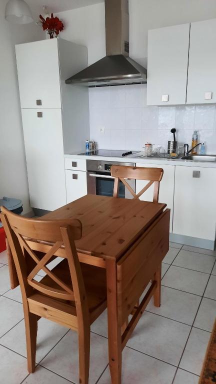 einen Holztisch und Stühle in der Küche in der Unterkunft F2 SUR LES HAUTEURS DE GERARDMER in Gérardmer
