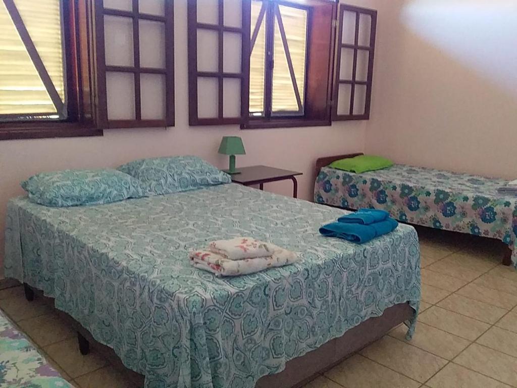聖佛朗西斯科迪伊塔巴波阿納的住宿－Fazenda São Felipe，一间卧室设有两张床和两个窗户。