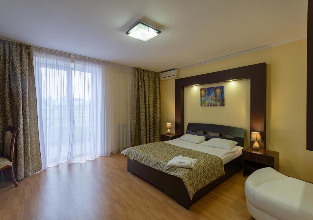 a bedroom with a bed and a large window at Kozatskiy Hotel in Kyiv