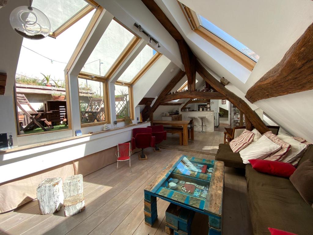 an attic room with windows and a couch and a table at Appart'hôtel Paris Roland-Garros in Boulogne-Billancourt