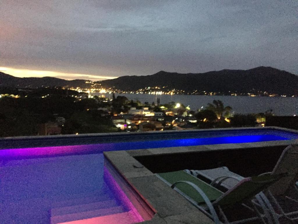 a swimming pool with chairs and a view of the water at Aloha spa in Florianópolis