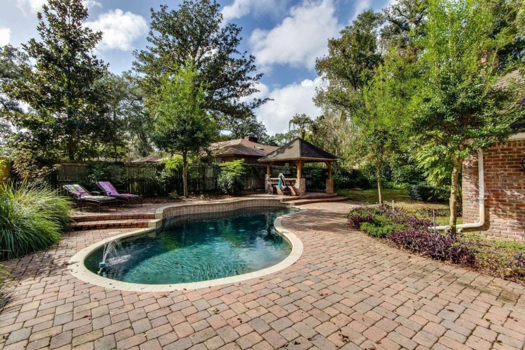 una piscina en un patio de ladrillo con cenador en English Cottage Pool Home Florida Style, en Orange Park