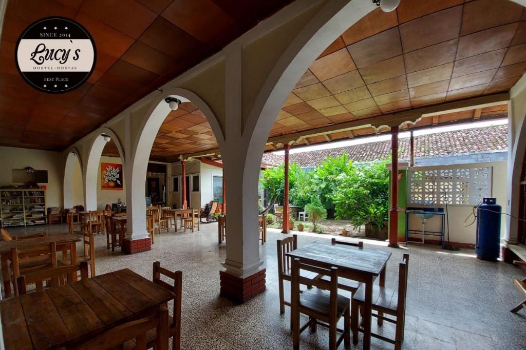 Casa Lucys Hostal في غرناطة: مطعم مع طاولة وكراسي في غرفة