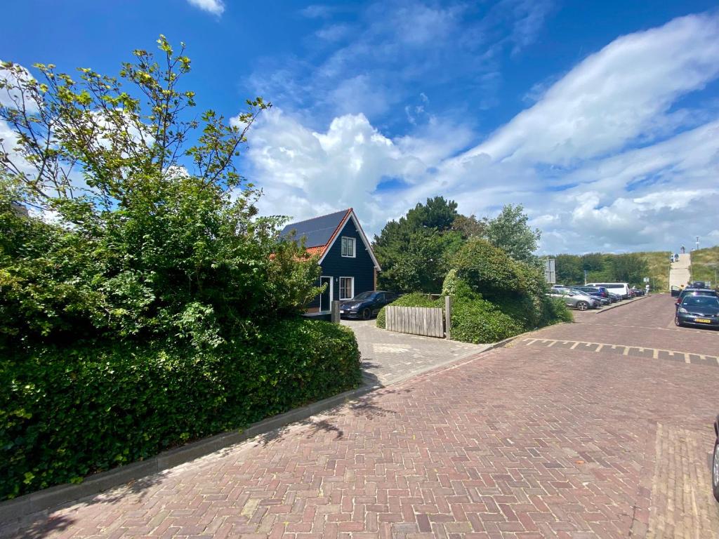 a house on the side of a brick road at Uniek huis onderaan de duinen -veel privacy- eigen parkeerplaats in Domburg