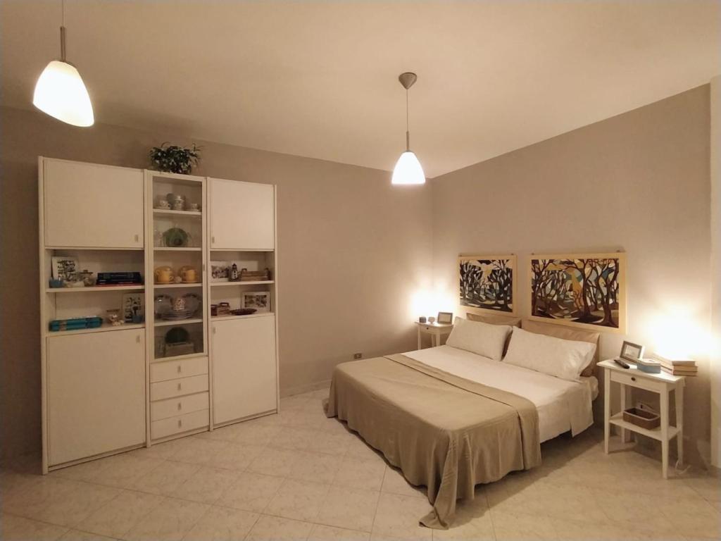 a bedroom with a bed and shelves and lights at A due passi dal mare in Moneglia