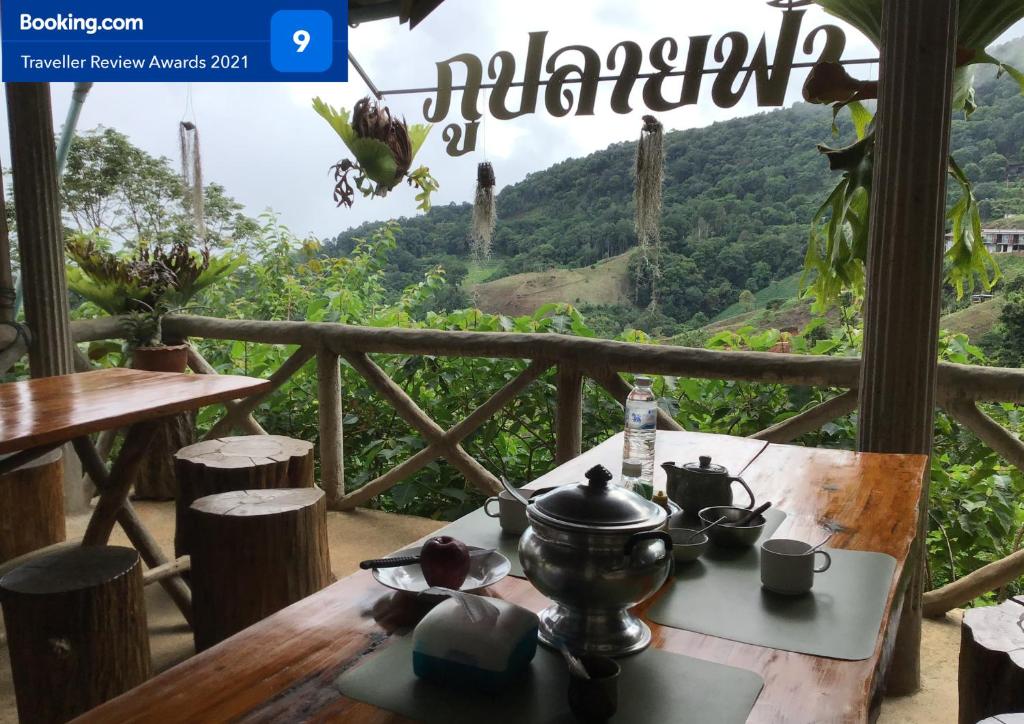 a tea set on a table with a view of a mountain at Phu Plai Fah in Chiang Rai