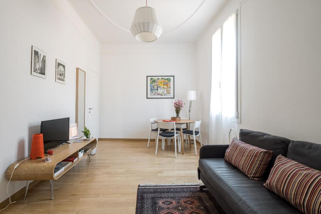 ein Wohnzimmer mit einem Sofa und einem Tisch in der Unterkunft Canonica Suites in Bologna