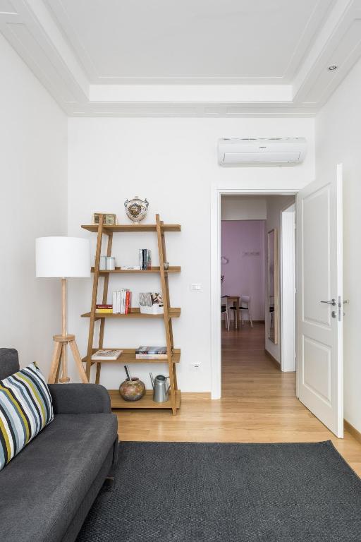 a living room with a couch and a book shelf at Canonica Suites in Bologna