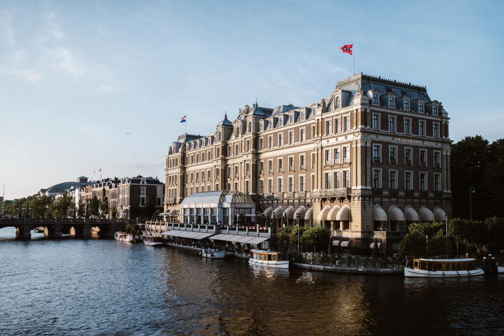 a large building with a boat in the water at InterContinental Amstel Amsterdam, an IHG Hotel in Amsterdam