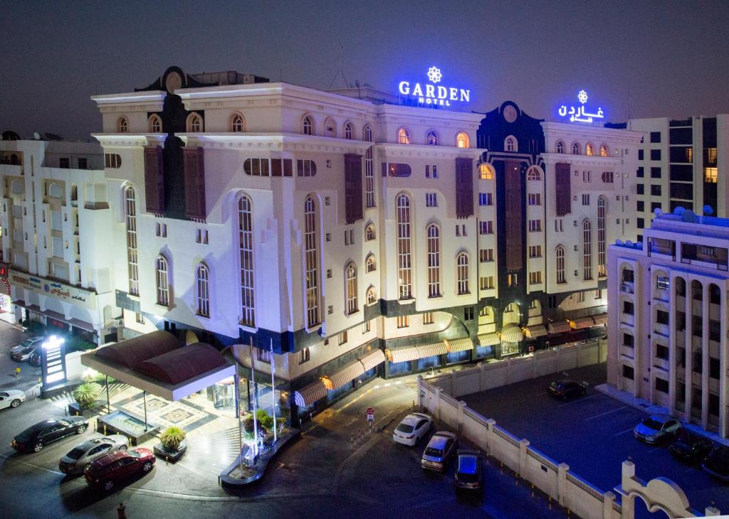 a large building with a sign on top of it at Garden Hotel Muscat By Royal Titan Group in Muscat
