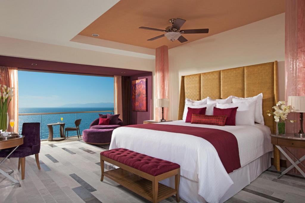 a bedroom with a large bed with a large window at Secrets Vallarta Bay Resort & SPA - Adults Only in Puerto Vallarta