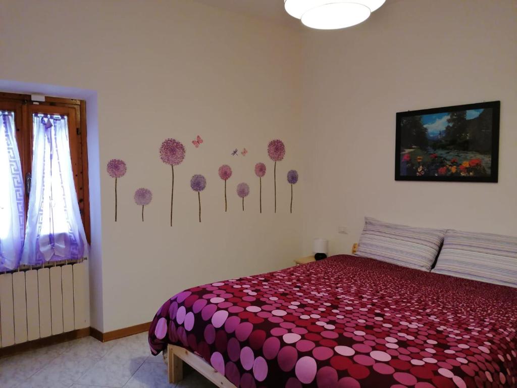 a bedroom with a bed with flowers on the wall at A casa di Iole tra il Chianti e la bella Firenze in Florence