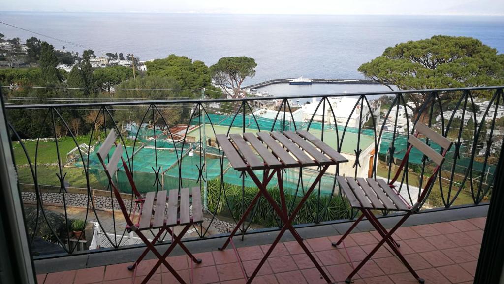 a balcony with two chairs and a swimming pool at La Marocella in Capri