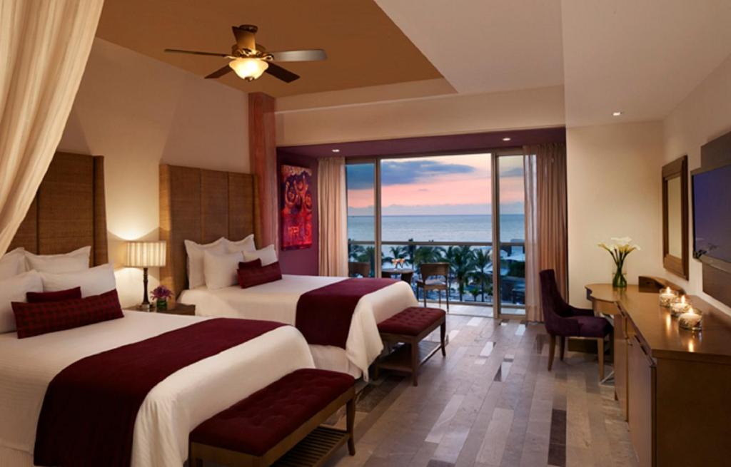 a hotel room with two beds and a balcony at Secrets Vallarta Bay Resort & SPA - Adults Only in Puerto Vallarta