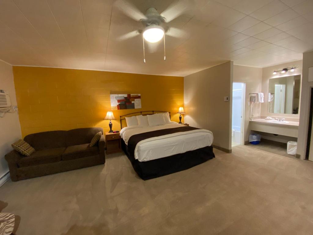 a large bedroom with a bed and a couch at Dauphin Inn Express in Dauphin