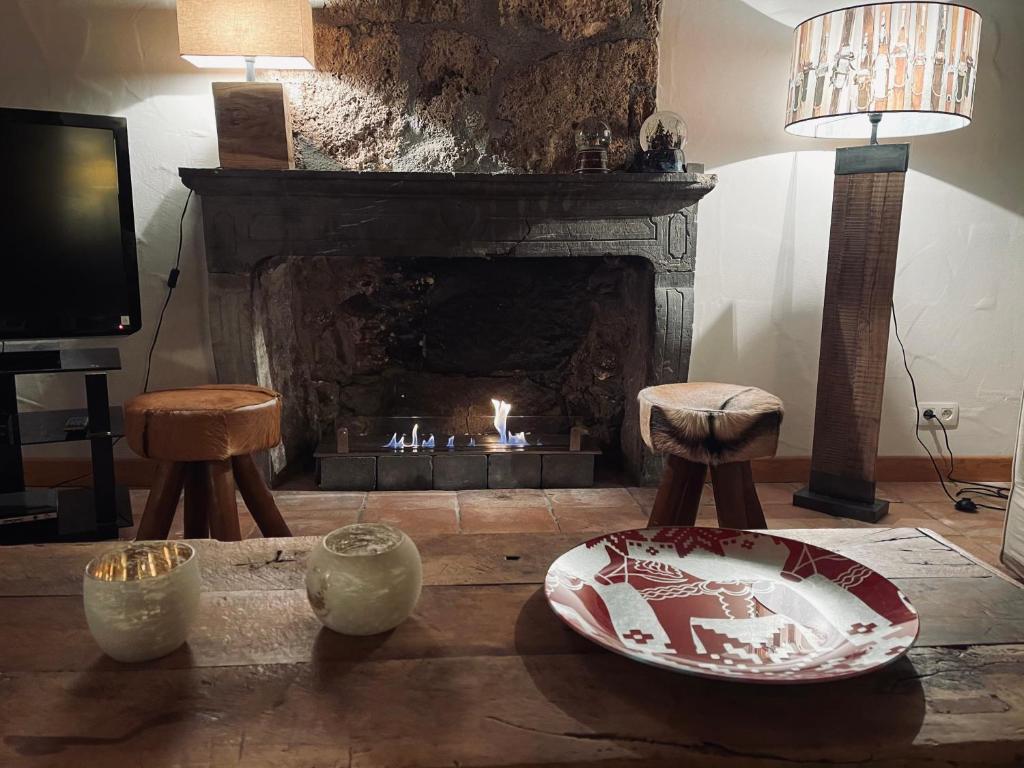 a living room with a fireplace and two stools at Maison du Bourg in Samoëns
